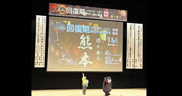 일본 구마모토현에서 개최된 회복기재활병동 연구대회에서 쿠마몽이 깜짝 등장해 인사하고 있는 모습. [사진] 재활뉴스